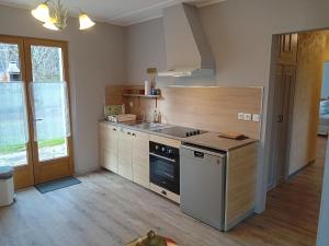 una cocina con fregadero y estufa horno superior en La Bertrandie, en Florimont-Gaumiers