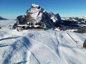 a ski lodge in the snow with a mountain at AlpinRetro-Apartment I Stylisch & zentral I See & Berge I Luzern I Zürich I Stoos I Rigi in Schwyz