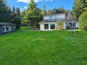 un patio con una casa y una mesa delante. en Hawick - House - Sleeps 9 - Hot Tub, en Denholm