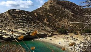 Captain's Villa - Sea Serenity in Folegandros في Áno Meriá: اطلالة على شاطئ فيه جبل في الخلفية