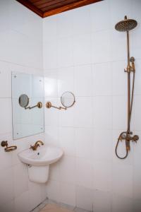 ein Badezimmer mit Waschbecken und Spiegel in der Unterkunft The Hub Train House Apartments in Zanzibar City