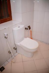 ein Badezimmer mit einer weißen Toilette in einem Zimmer in der Unterkunft The Hub Train House Apartments in Zanzibar City