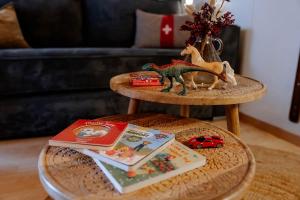a table with a toy dinosaur and books on it at AlpinRetro-Apartment I Stylisch & zentral I See & Berge I Luzern I Zürich I Stoos I Rigi in Schwyz