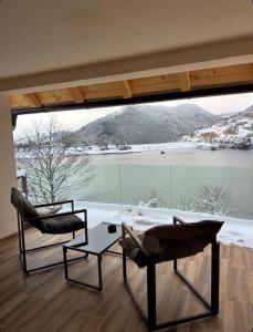 zwei Stühle und ein Tisch vor einem großen Fenster in der Unterkunft Zoranov Konak Vista in Jevtići