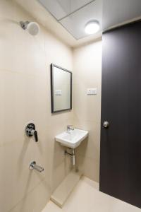 a bathroom with a sink and a mirror at House of KP by Union in Pune