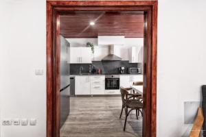 Una cocina con gabinetes blancos y una mesa con sillas. en Casa Tilola, en Los Llanos de Aridane 15 fotos más