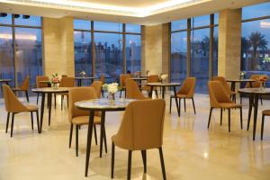 a restaurant with tables and chairs and windows at Medhal qurtuba by Prime hotels in Riyadh