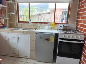 eine kleine Küche mit Herd und Spüle in der Unterkunft Häuschen nahe Cotopaxi-House near Cotopaxi in Machachi