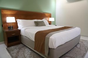 a large bed in a hotel room with two lamps at Medhal qurtuba by Prime hotels in Riyadh +18 photos