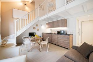 a living room with a table and a kitchen with a staircase at VILLA CARLA- Hyper Centre - Climatisation - Wifi in Menton