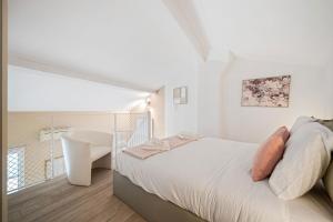 a white bedroom with a bed and a white chair at VILLA CARLA- Hyper Centre - Climatisation - Wifi in Menton