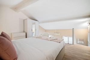 a white bedroom with a large bed and a window at VILLA CARLA- Hyper Centre - Climatisation - Wifi in Menton +8 photos