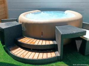 a hot tub with two wicker chairs around it at רגעים קסומים בגלבוע in Avital