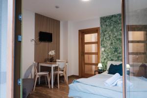 a bedroom with a bed and a table and a desk at Apartmány Kamenice "Kamčatka" in Březová