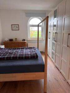 a bedroom with a bed and a window at Gut Ellernwurth in Wurster Nordseeküste