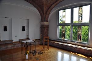 Gästehaus Aurelius Arkenau في Niederdorla: غرفة بها نافذتان كبيرتان وطاولة بها تماثيل صغيرة