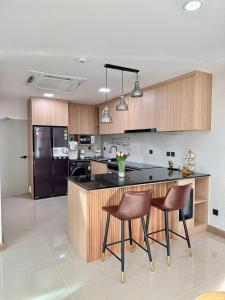 eine Küche mit einer schwarzen Theke und braunen Stühlen in der Unterkunft Bann Nai clam Talang in Ban Pak Lak