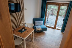 a living room with a table and a chair and a television at Apartmány Kamenice "Kamčatka" in Březová
