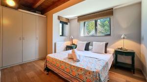 1 dormitorio con 1 cama con 2 mesas y una ventana en Morada la Tosa, en Alp