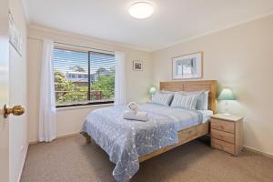 a bedroom with a large bed and a window at The Crows Nest Eden in Eden