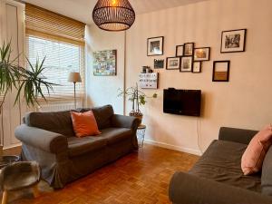 a living room with a couch and a tv at St Catherine - Sweet home - Bxl - Studio Apartment with city view in Brussels