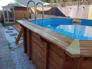 ein Außenpool mit Holzdeck und ein Schwimmbecken in der Unterkunft B&B Tra mare e montagna - sauna e piscina in San Giorgio di Pesaro