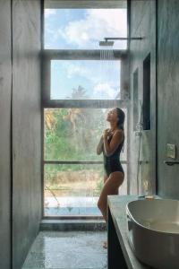 a woman standing in front of a window in a bathroom at vrihee resort in Weligama +27 photos