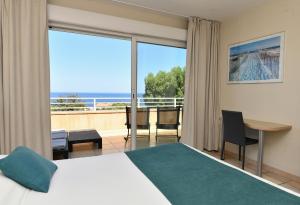 Una habitación con cama y vistas al océano. en Calvi Résidence, Appart'hôtel, en Calvi