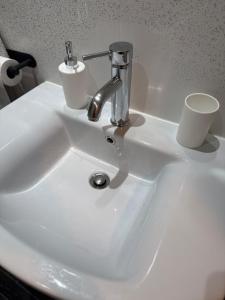 a white sink with a faucet and cups on it at 4Bed Grimsby Contractor Work Crew Stay in Grimsby