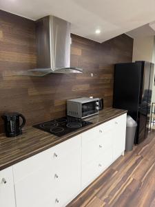 a kitchen with a microwave and a stove top oven at 4Bed Grimsby Contractor Work Crew Stay in Grimsby