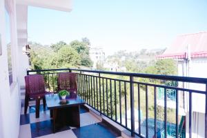a balcony with a table and chairs and a view at Dhananjay home stay in Dharampur