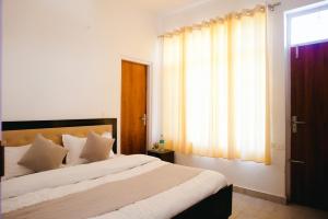 a bedroom with two beds and a window at Dhananjay home stay in Dharampur +2 photos