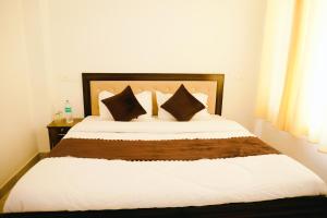 a bedroom with a large bed with two pillows at Dhananjay home stay in Dharampur