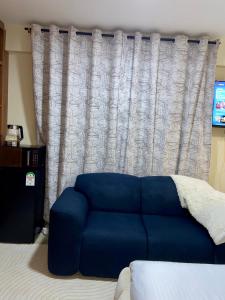 Un sofá azul sentado frente a una cortina. en Terus studio, en Nanyuki