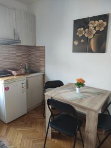 a kitchen with a wooden table and chairs and a kitchen with a sink at Vila Čair DOPLATA ZA BAZEN in Soko Banja