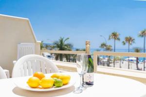 a table with a plate of fruit and a bottle of wine at Luxury, Frontline Burriana Beach, Nerja in Nerja