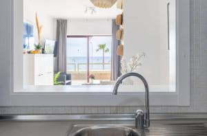 a kitchen sink with a window with a view of the beach at Luxury, Frontline Burriana Beach, Nerja in Nerja +24 photos