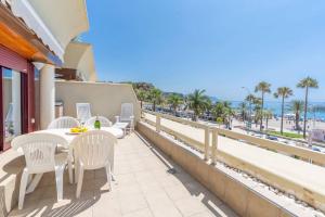 a balcony with a table and chairs and the beach at Luxury, Frontline Burriana Beach, Nerja in Nerja