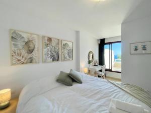 a white bedroom with a large bed and a desk at Luxury, Frontline Burriana Beach, Nerja in Nerja
