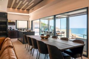 ein Esszimmer mit einem großen Holztisch und Stühlen in der Unterkunft Luxury House Mirador Calaceite Torrox Costa, with Private Pool Jacuzzi and Wellness in Torrox Costa