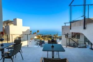 einen Blick vom Balkon eines Hauses mit Tischen und Stühlen in der Unterkunft Luxury House Mirador Calaceite Torrox Costa, with Private Pool Jacuzzi and Wellness in Torrox Costa