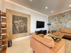 ein Wohnzimmer mit Sofa und Fernseher in der Unterkunft Luxury House Mirador Calaceite Torrox Costa, with Private Pool Jacuzzi and Wellness in Torrox Costa