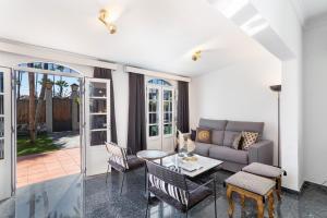 ein Wohnzimmer mit einer Couch und einem Tisch und Stühlen in der Unterkunft Exclusive Villa with Heated Pool in Maspalomas