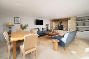 a living room with a blue couch and a table at Barn Cottage Painswick in Painswick