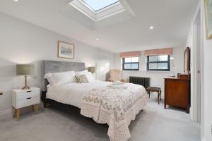 a bedroom with a bed and a table and a chair at Barn Cottage Painswick in Painswick