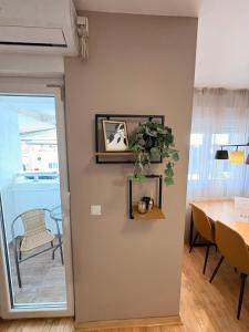 Un comedor con una mesa y una planta en la pared. en NAR Royalton Apartment #01, en Niš 2 fotos más
