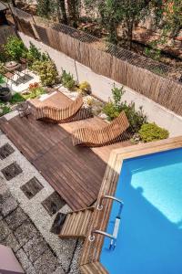 Dos sillas y una piscina junto a un deck de madera. en B&B Tra colline marchigiane - sauna e piscina, en San Giorgio di Pesaro