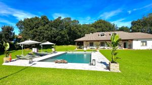 a pool in a yard with chairs and a house at La Hondonada in Somo