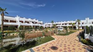 een binnenplaats van een gebouw met een bank en palmbomen bij Casa Reinolds in El Pozo del Esparto