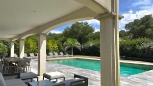 eine Terrasse mit Pool, Stühlen und einem Tisch in der Unterkunft Villa 300m2 piscine chauffée et jacuzzi-spa de nage in 